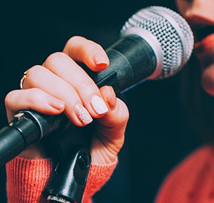 Close-up of woman singing into microphone