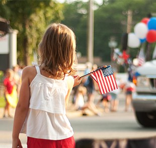 Girl waves American Flag at parade