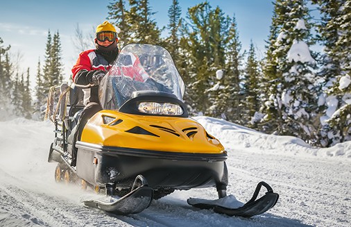 Man driving yellow snowmobile