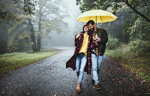 Young couple walks down street in the rain